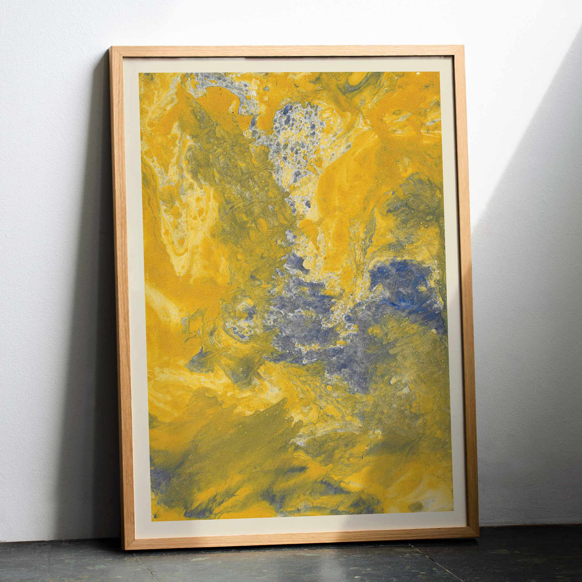 Margarete Rumpf Yellow marbled paper poster with swirling ochre, cream and blue-grey abstract textures, with wooden magnetic frame on white background