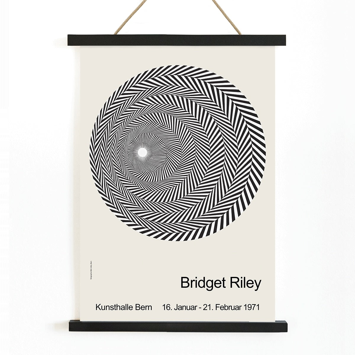 Bridget Riley Blaze Exhibition Poster featuring hypnotic black and white spiral geometric design on light background, with wooden magnetic frame on white background