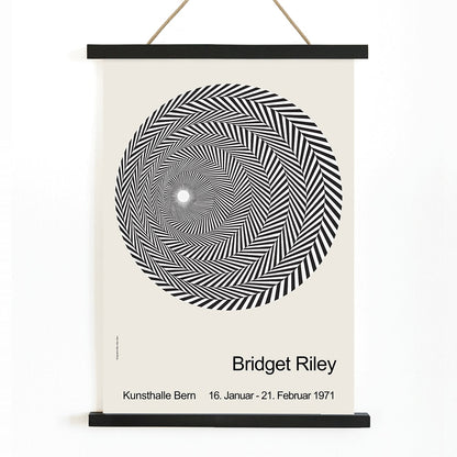 Bridget Riley Blaze Exhibition Poster featuring hypnotic black and white spiral geometric design on light background, with wooden magnetic frame on white background