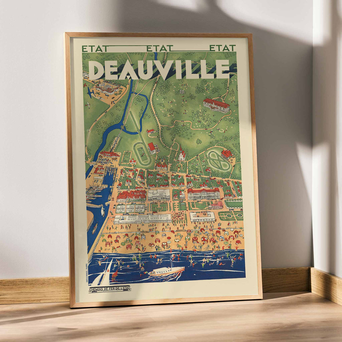 Deauville railway travel poster vintage coastal resort map with beaches boats waterways and countryside, with wooden magnetic frame on white background