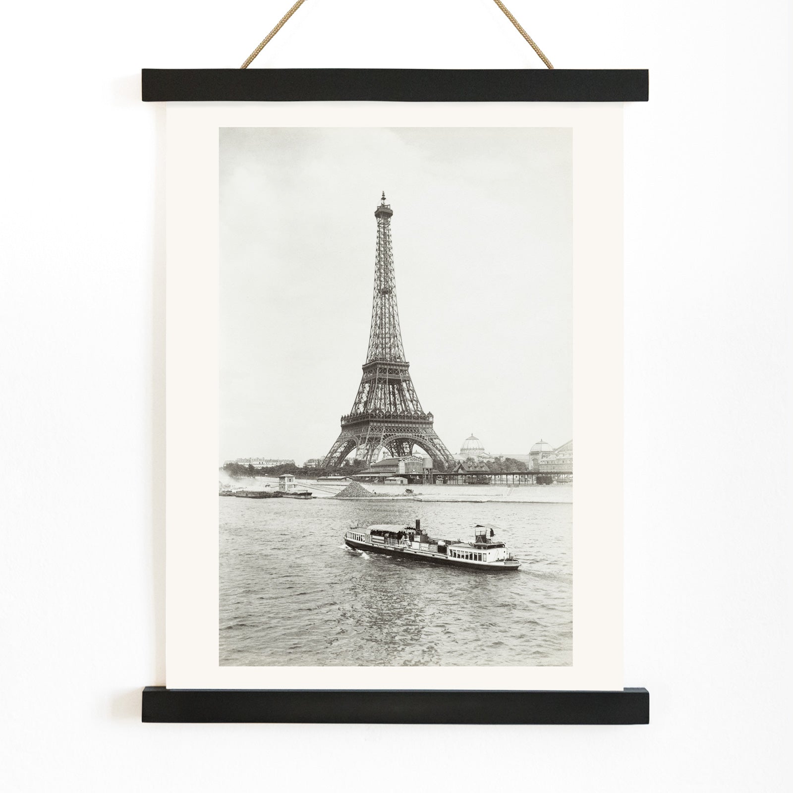 Black and white photograph and poster of the Eiffel Tower in Paris with a vintage boat on the Seine river wall decor artwork, with wooden magnetic frame on white background