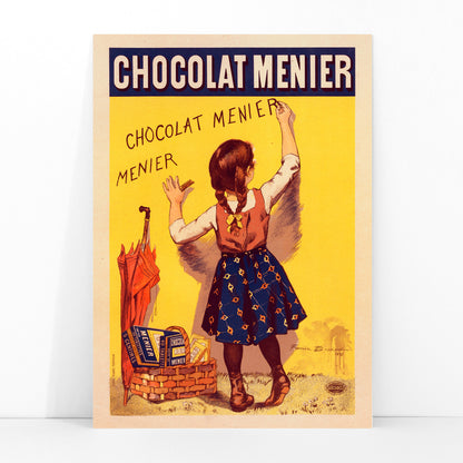Chocolat Menier poster by Firmin Bouisset featuring a young girl writing on a yellow wall with a basket of chocolate and an umbrella, framed and displayed in modern living room decor