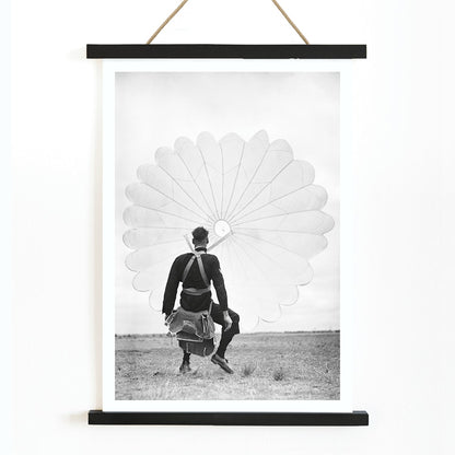 Air force parachuter landing and standing with deployed parachute by Ray Olsen poster, with wooden magnetic frame on white background