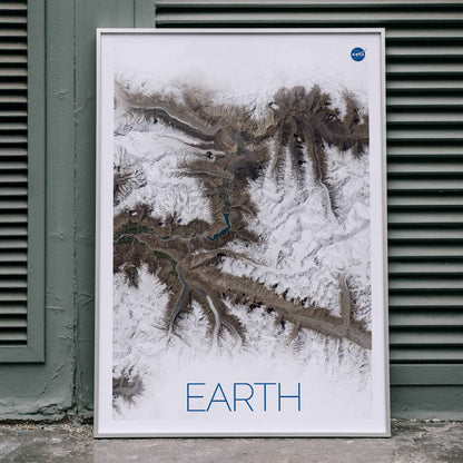 Stunning NASA satellite image of Earth showing snowy mountain ranges and rugged terrain high resolution poster, framed and displayed in home decor