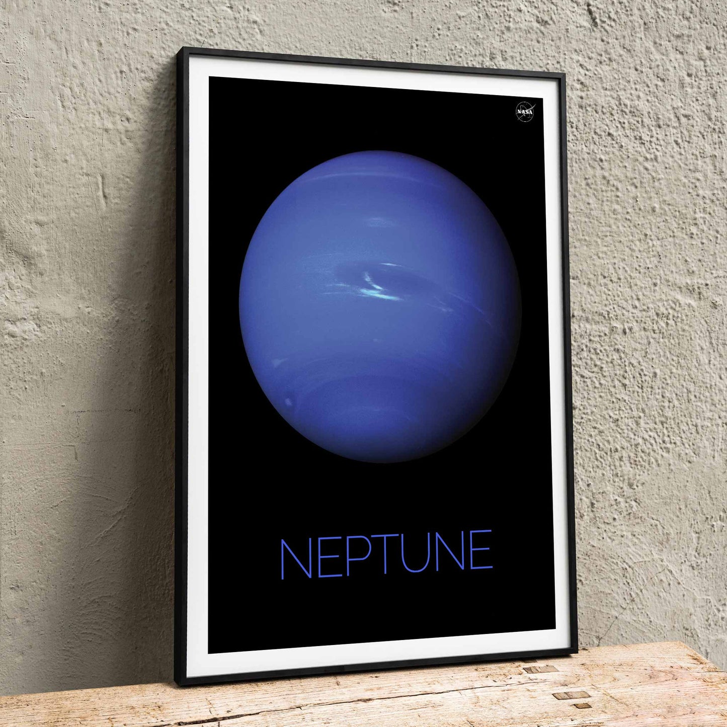 NASA poster of Neptune showing a detailed blue planet against a black background with the title Neptune at the bottom, framed and displayed in home decor