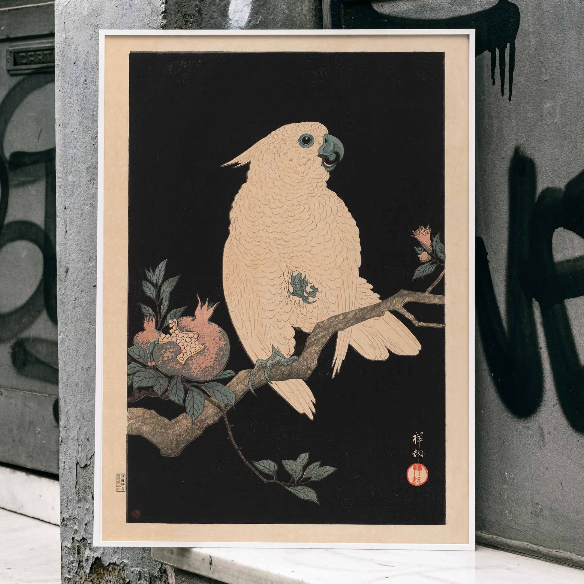 White cockatoo perched on a branch with pomegranate artwork by Ohara Koson poster, framed and displayed in home decor