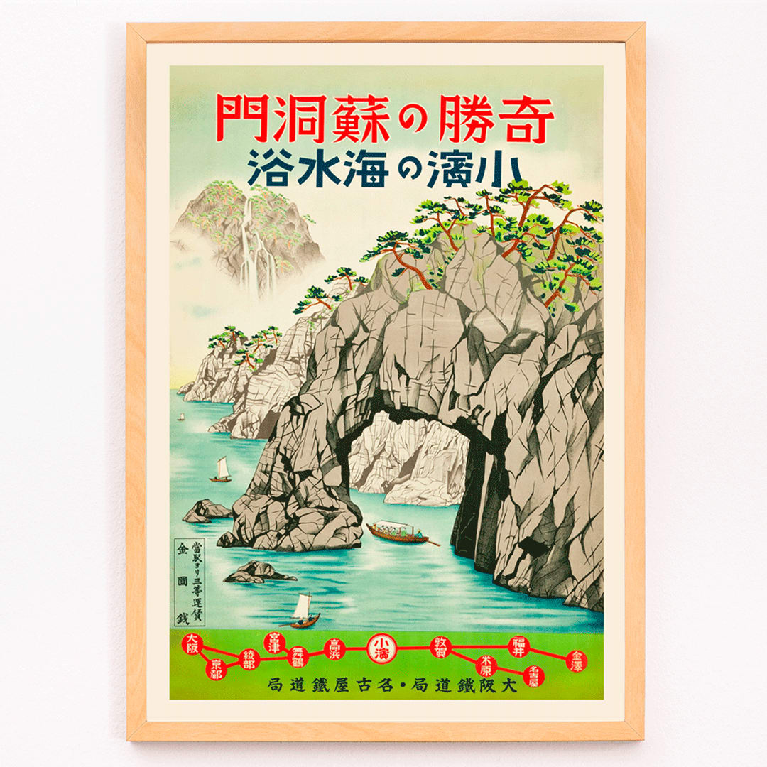 Vintage seaside poster with boats lush greenery and rocky cliffs Sea Bathing in Obama Fukui by Osaka and Nagoya Rail Agency, framed and displayed in modern living room decor