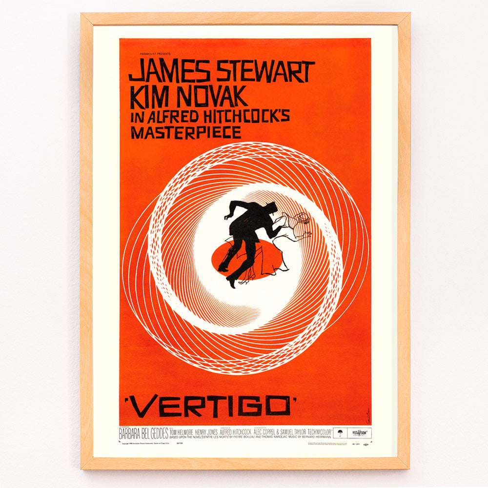 Closeup detail of Vertigo movie poster by Saul Bass featuring vibrant orange background swirling spiral and silhouetted figures graphic design