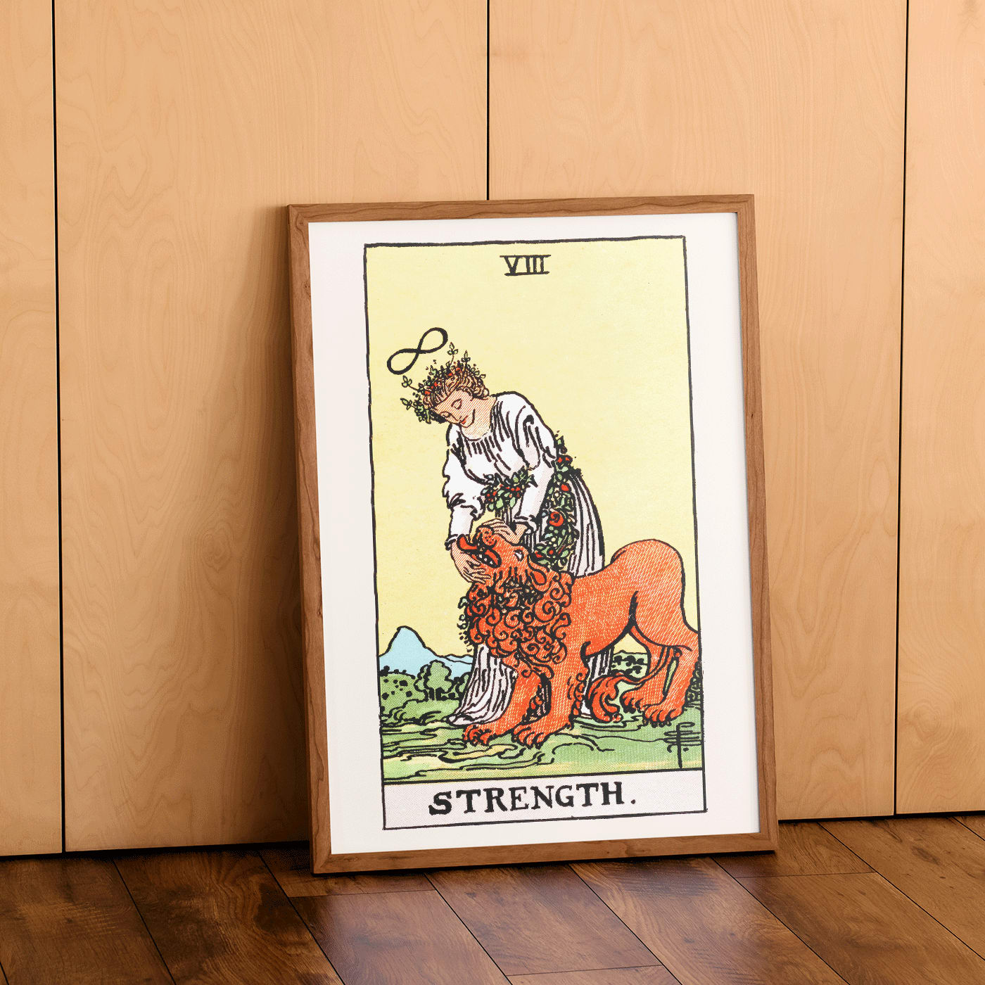 Tarot Strength card by Rider Waite showing a woman calming a lion with an infinity symbol above her head, framed and displayed in home decor