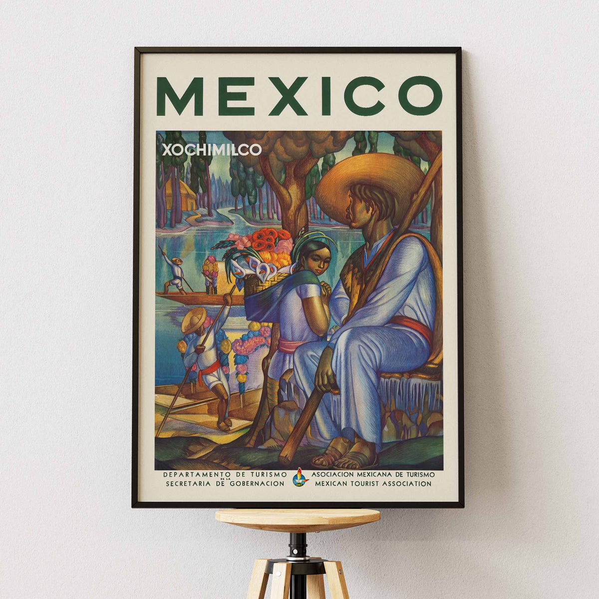 Xochimilco poster with canal boats, flower vendors, and local travelers beneath trees in vivid green, blue, orange, and red, framed and displayed in modern living room decor